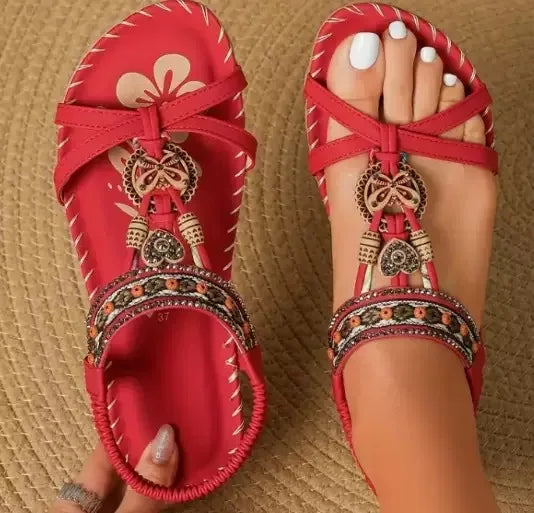 Red embellished sandals on a textured surface