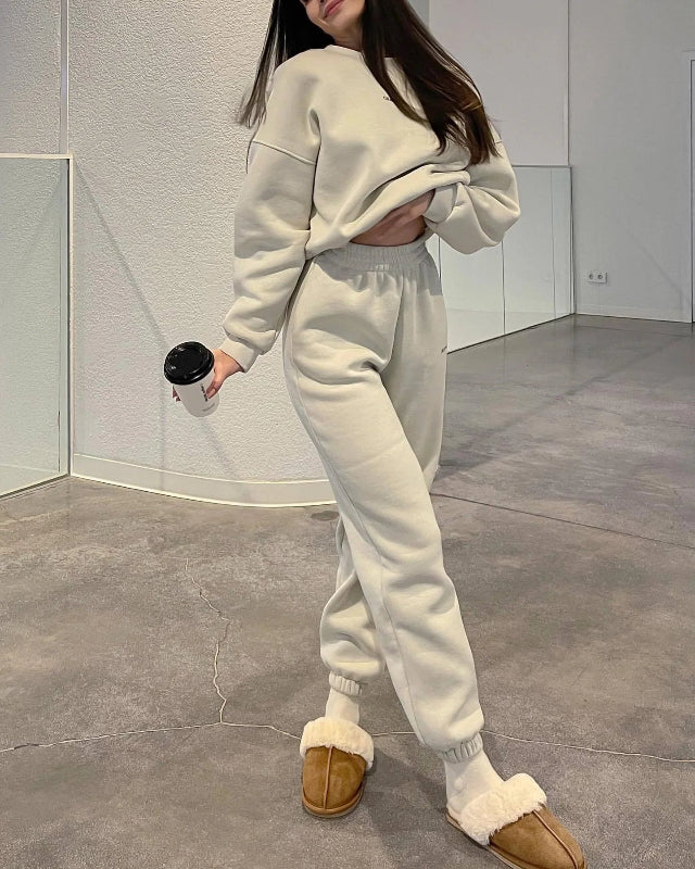 Person wearing a white outfit with brown slippers in an indoor setting