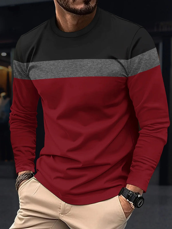 Man wearing a black, gray, and red long-sleeve shirt with beige pants.