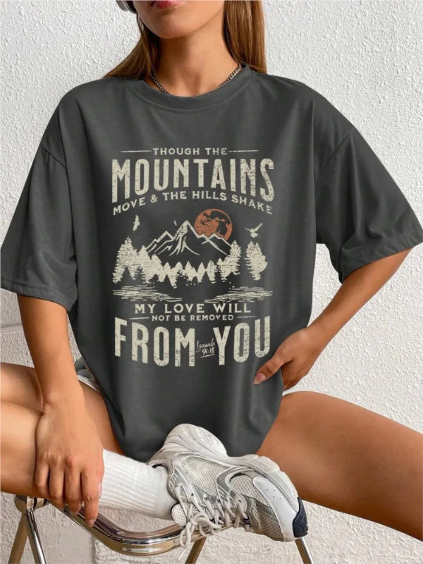 Person wearing a dark gray t-shirt with a mountain graphic and text.