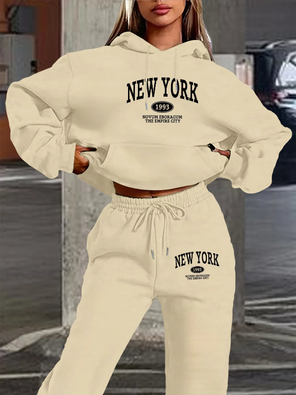 Beige 'New York' hoodie and pants set with text design on a blurred street background