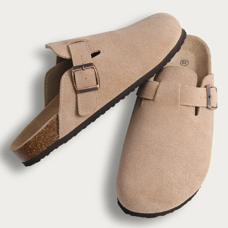 Pair of beige clogs with buckles on a light gray background