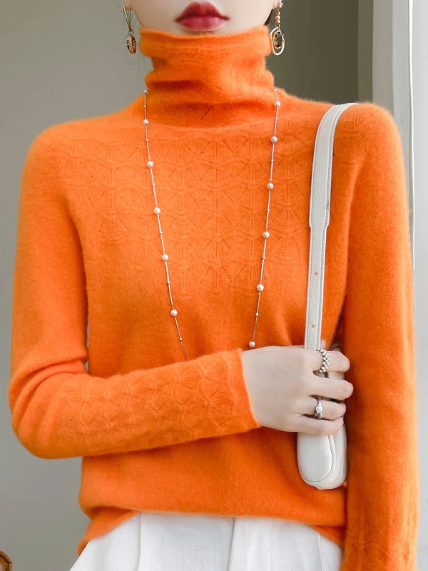 Person wearing an orange turtleneck sweater holding a white handbag.