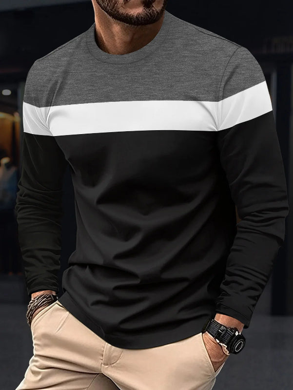 Man wearing a black, gray, and white long-sleeve shirt with beige pants.
