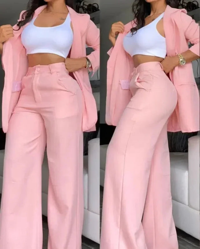 Woman wearing a pink suit with a white top in an indoor setting