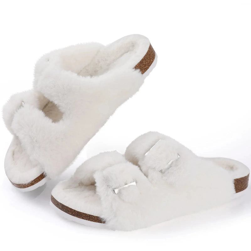 Pair of white fluffy slippers with brown soles on a white background