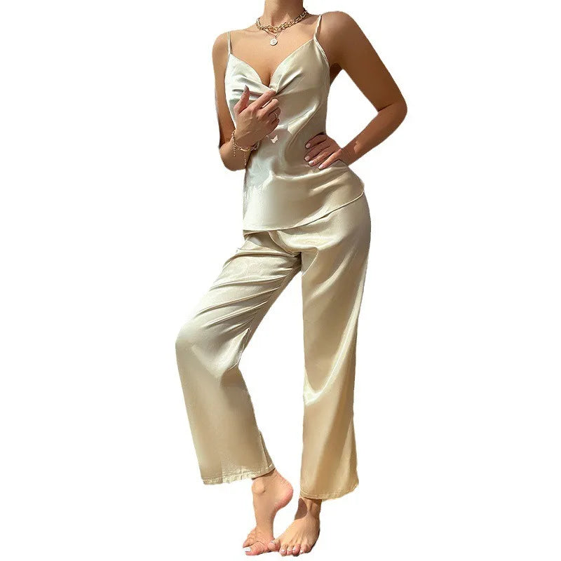 Woman wearing a cream satin pajama set on a white background