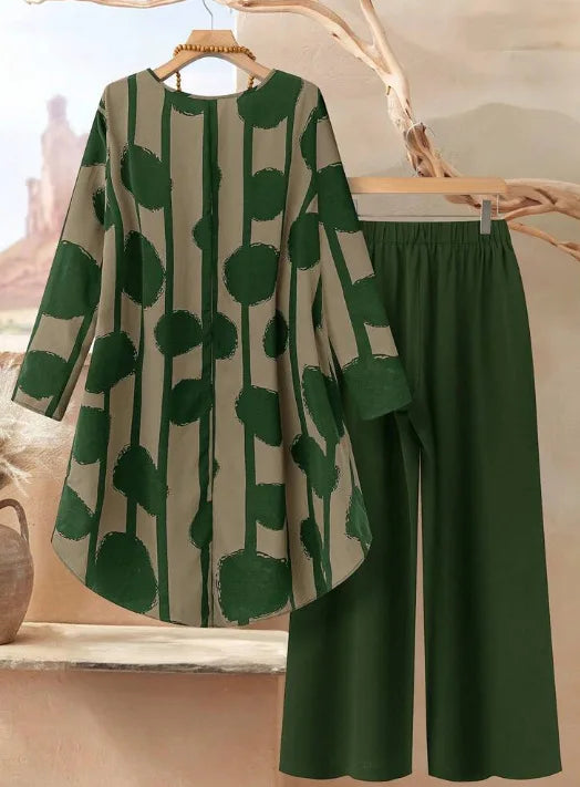 Green and beige patterned top with green pants on a hanger against a neutral background