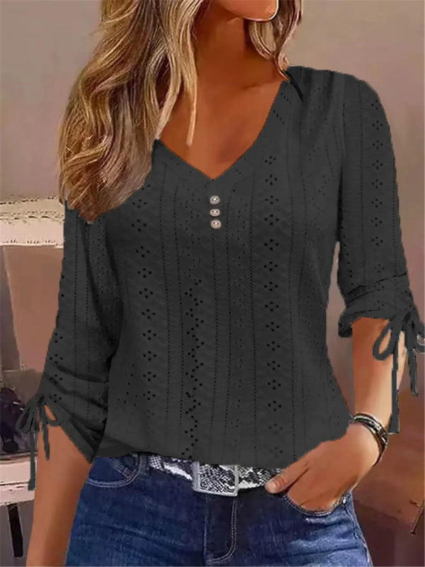 Woman wearing a black lace-up top with a blurred background