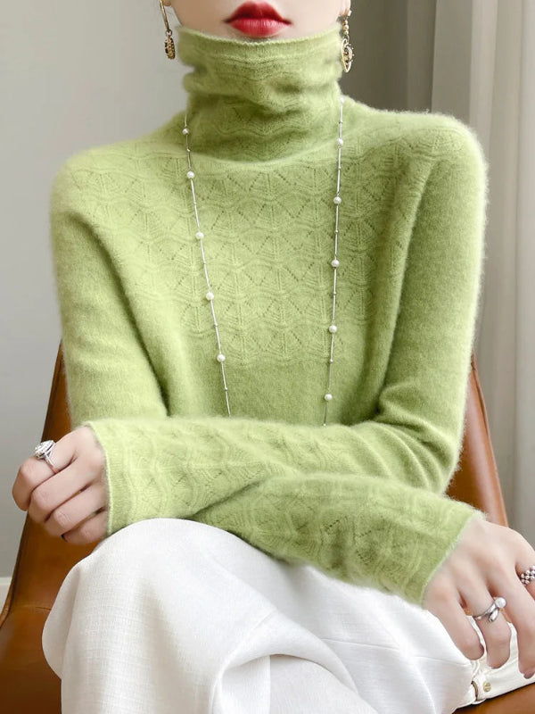 Person wearing a green turtleneck sweater with a neutral background