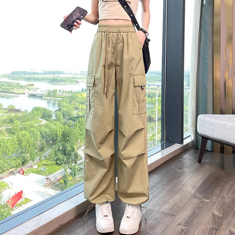 Person wearing beige cargo pants standing by a large window with a scenic view.