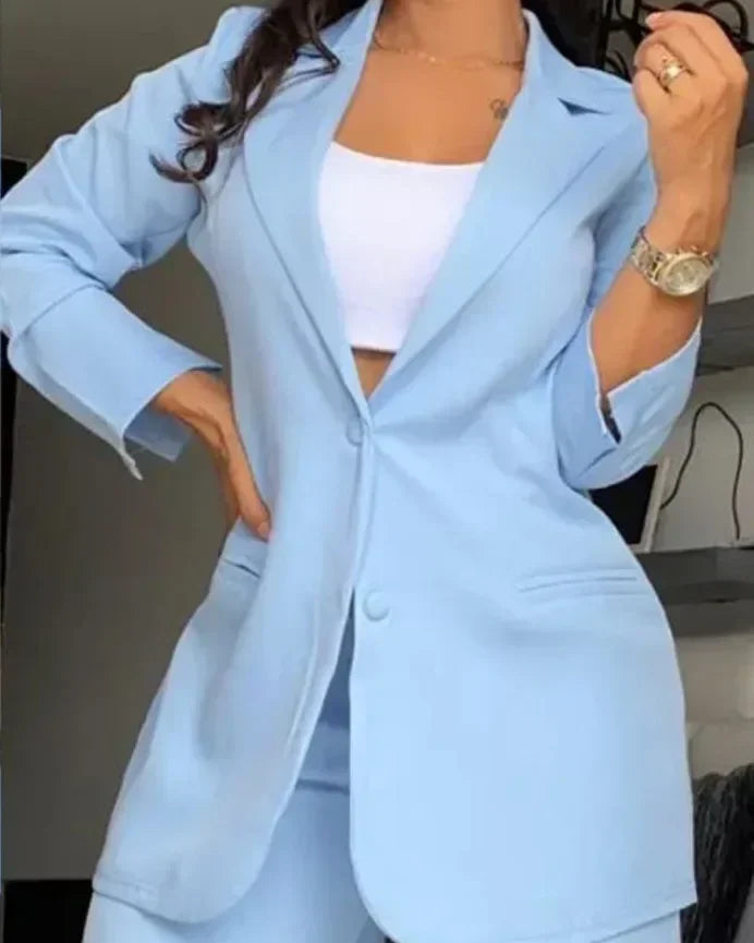 Person wearing a light blue suit with a white top indoors.