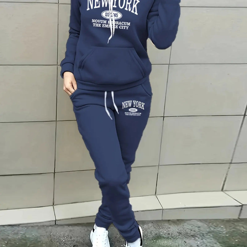 Person wearing a navy blue 'New York' tracksuit against a tiled wall.