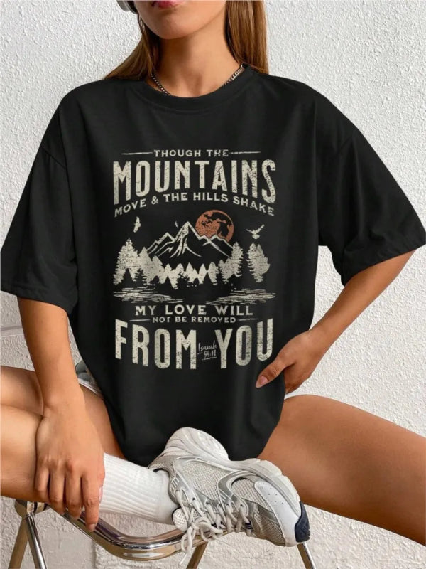 Person wearing a black t-shirt with a mountain graphic and text.