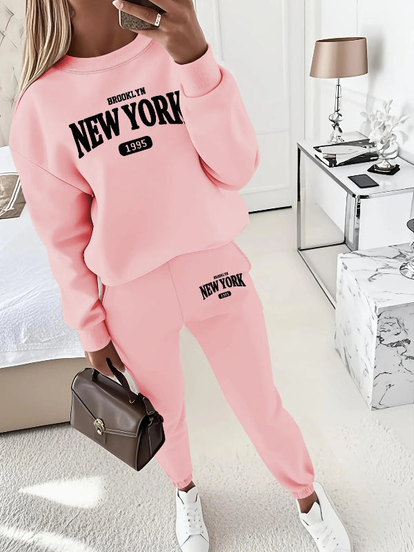 Person wearing a pink 'New York' themed outfit in a modern room.