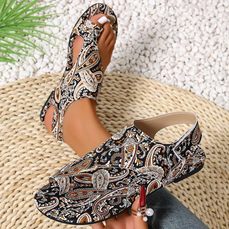 Patterned sandals worn by a person on a textured surface
