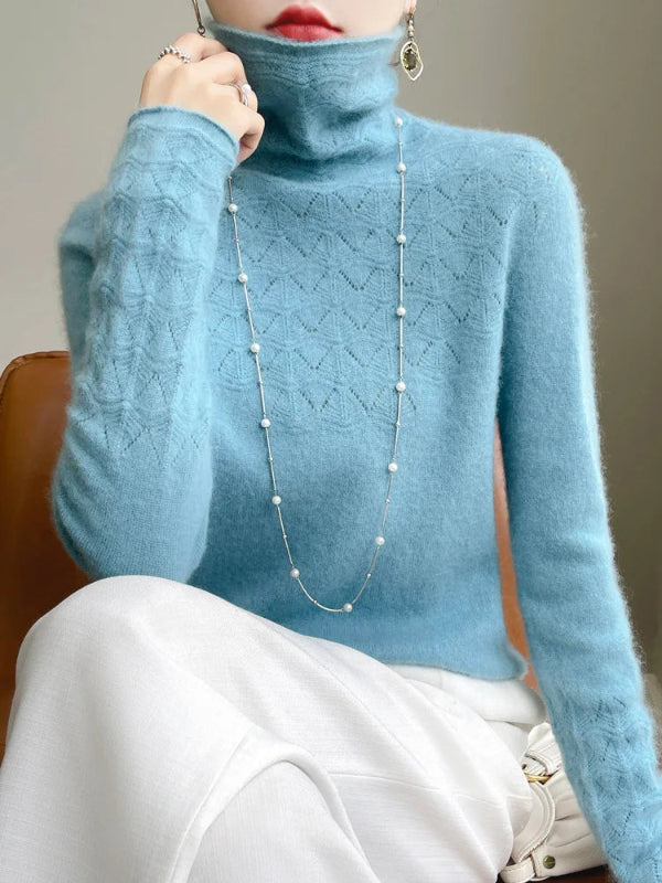 Person wearing a blue turtleneck sweater with a neutral background