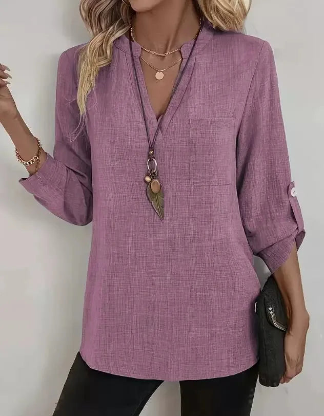 Purple blouse worn by a person with a plain background