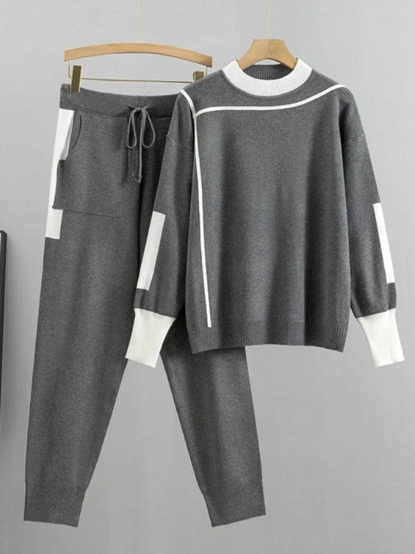 Gray tracksuit with white accents on hangers against a gray background