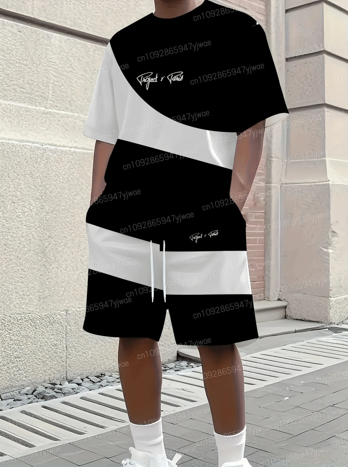 Person wearing a black and white striped outfit with brand logos against a brick wall.