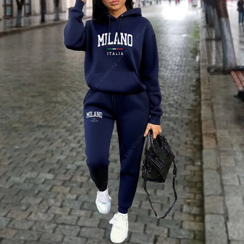 Person wearing a navy blue 'Milano Italia' tracksuit on a city street.