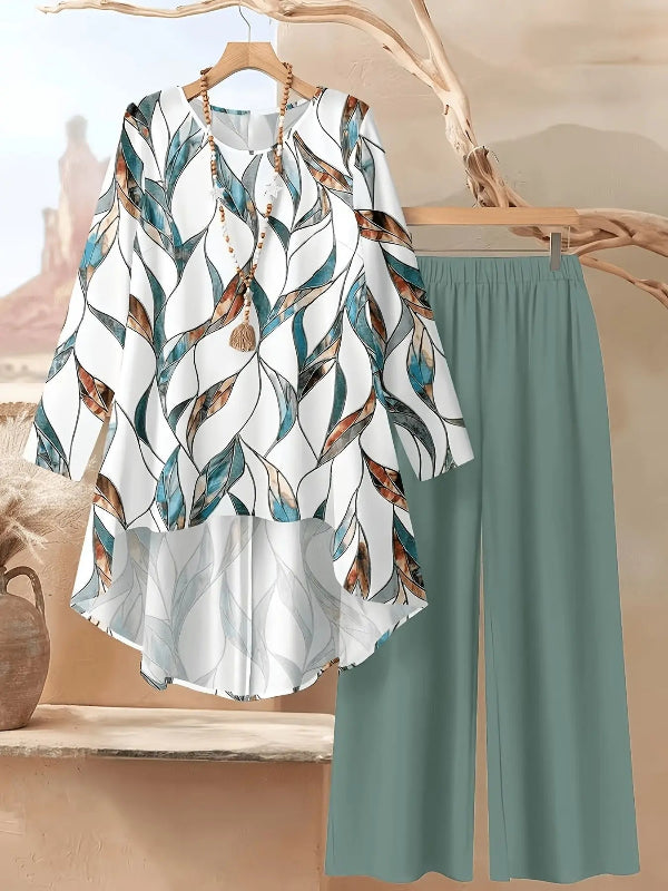 Floral blouse and green pants on hangers against a neutral background