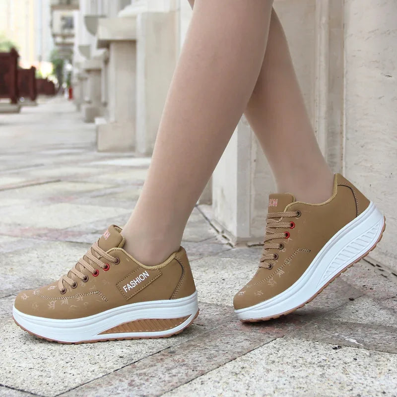 Brown sneakers with white soles worn on a stone pavement.