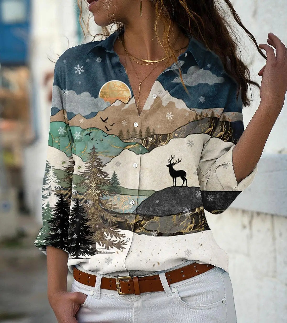 Person wearing a shirt with a nature-themed design featuring mountains and a deer.