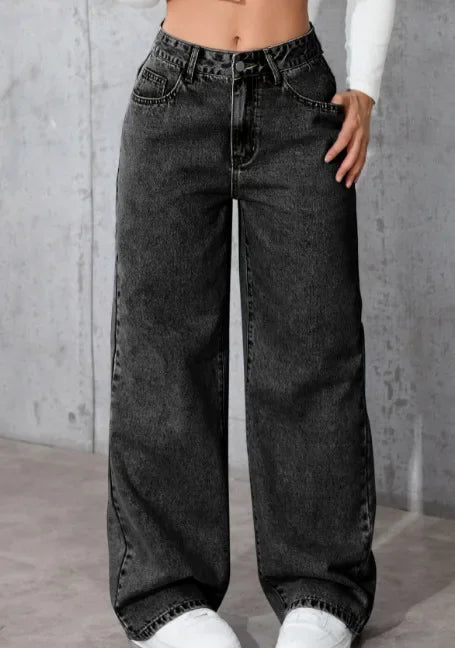 Black wide-leg jeans worn by a person against a gray background