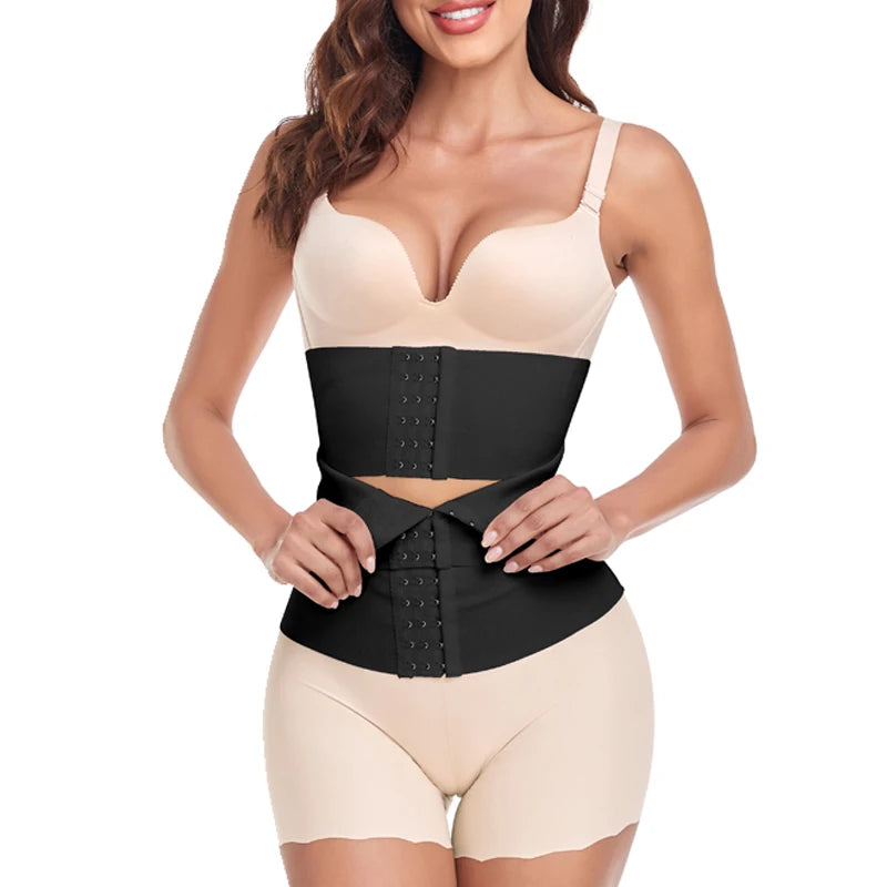 Woman wearing a black waist trainer with beige top and shorts on a white background