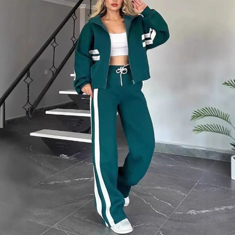 Woman wearing a teal tracksuit with white stripes in an indoor setting.