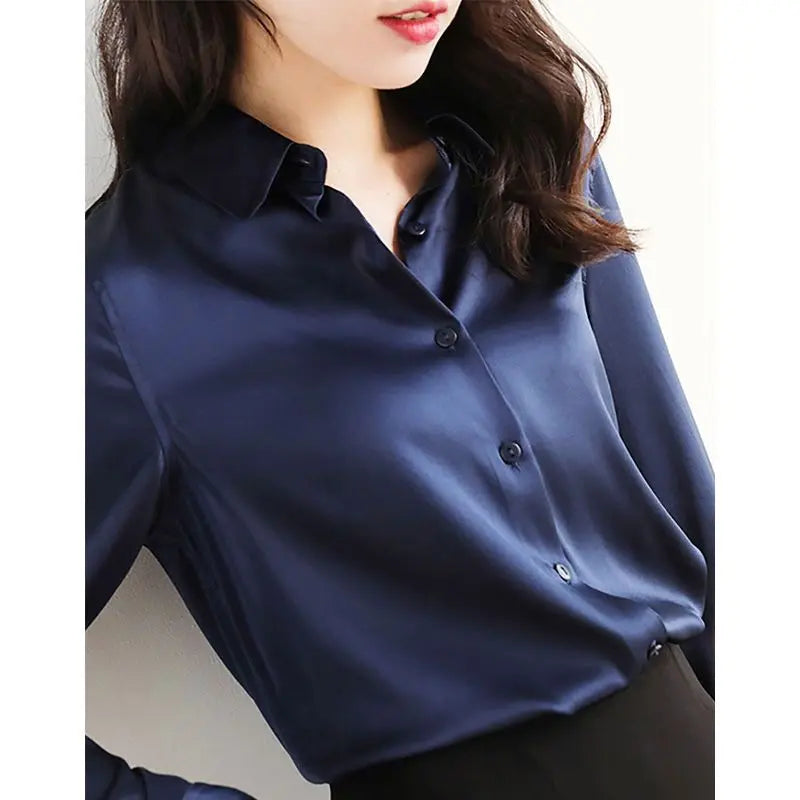 Navy blue satin blouse worn by a person on a plain background
