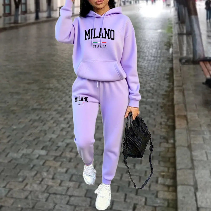 Person wearing a lavender 'Milano Italia' tracksuit on a city street.