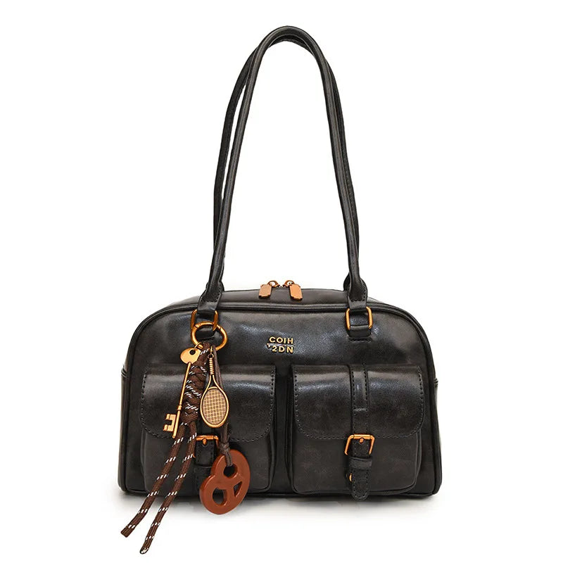 Black handbag with decorative charms on a white background