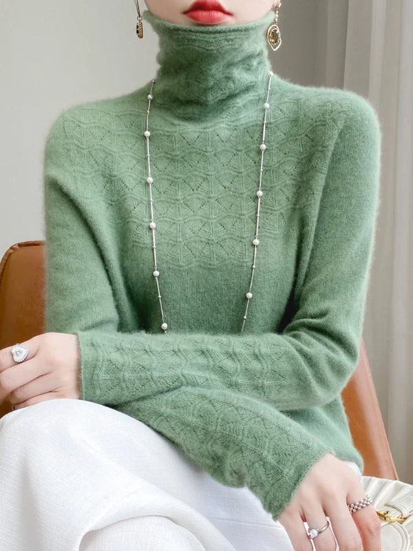 Person wearing a green turtleneck sweater with a neutral background