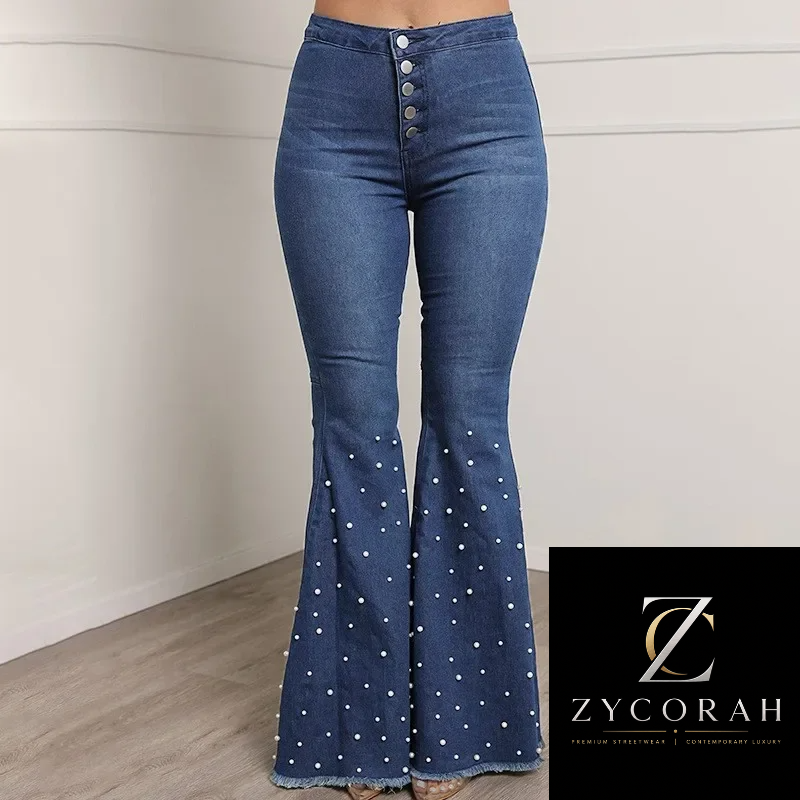 A model wears high-waisted blue denim flare jeans with a button fly and white polka dots on the flared legs, shown in an indoor setting with a Zycorah brand logo overlay in the bottom right corner.