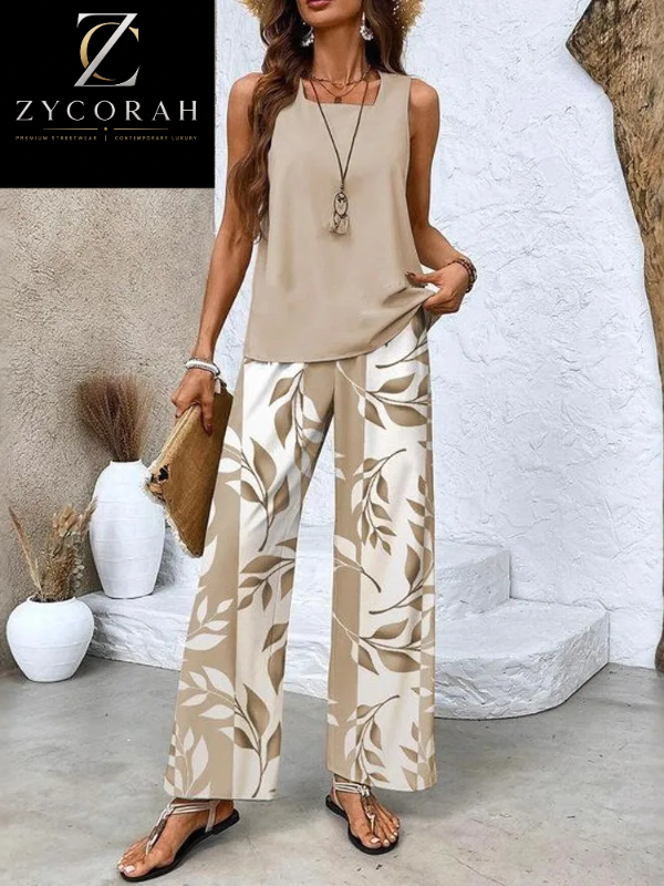 A woman models a sleeveless beige top and wide-leg pants with a beige and off-white leaf pattern, styled with a straw hat, necklace, and sandals. The ZYCORAH brand logo is visible in the top left corner.