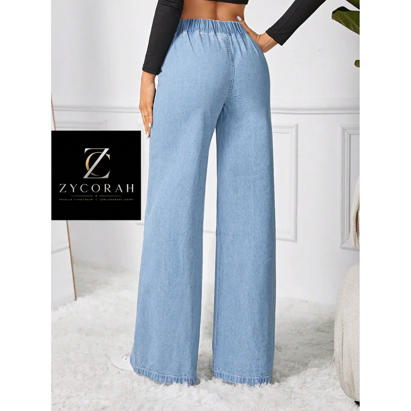 Light blue wide-leg denim pants with an elastic waistband, shown on a model in a styled indoor setting. A black brand card for ZYCORAH is visible on the left side of the image.