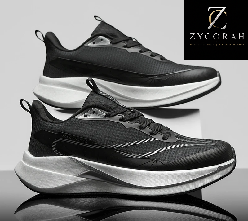 Two black athletic sneakers with thick white midsoles, displayed on a reflective surface against a gray background. A Zycorah brand logo is visible in the top right, and a promotional banner at the bottom reads 'GOOD QUALITY +50 UP TO % off'.