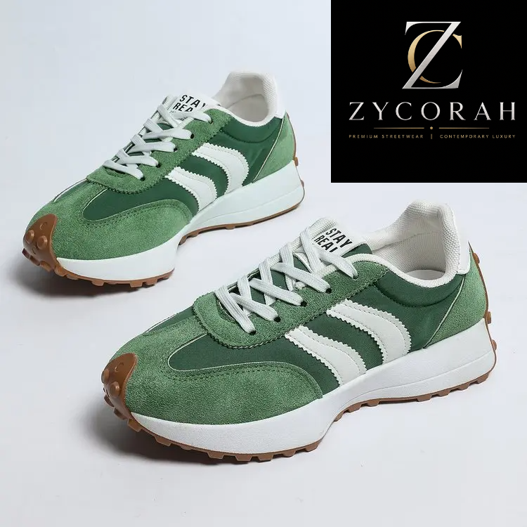 A pair of green and white low-top sneakers with suede panels, white laces, and brown rubber toe caps and soles, shown on a light gray background with a black Zycorah brand logo in the top right corner.