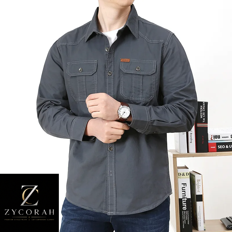 A man wearing a dark gray long-sleeve button-up shirt with two chest pockets, shown from the neck down against a white background with a bookshelf and a Zycorah logo in the lower left corner.